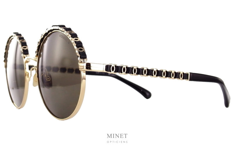 Les Lunettes solaires Chanel 4265-Q sont de très belles lunettes roneds en métal. La partie supérieure de la face, ainsi que les branches sont décorées comme une les chaines, détails omniprésents de la marque,  des sacs. Une jolie chaine de double C entrelacé d'une très belle lanière de cuir. 