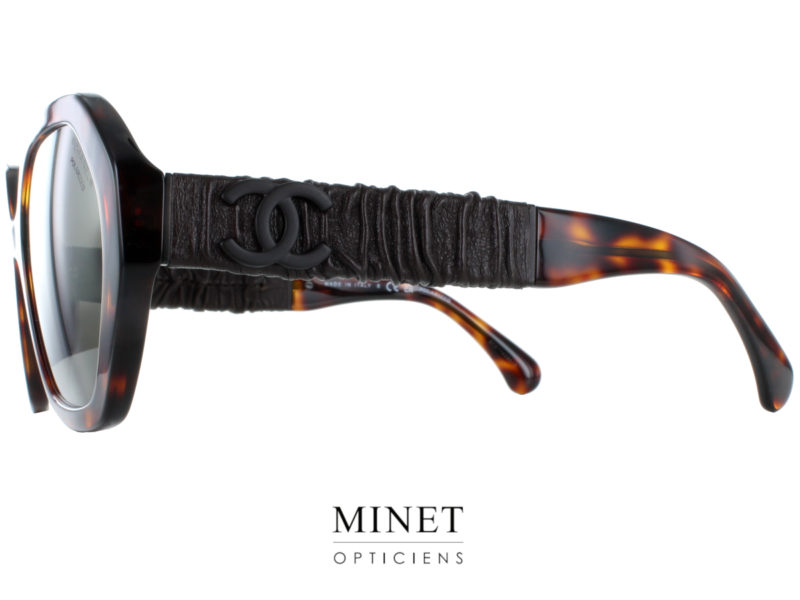 Lunettes de soleil Chanel 5475-Q Noires.  Grandes lunettes solaires hexagonales pour dames.  La monture pourrait paraître simple mais les branches sont joliment décorée de cuir. 